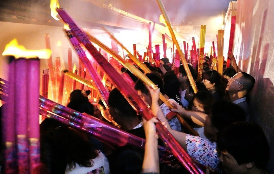 安徽六安高考学生家长冒雨抢头香拜"神树"